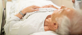 A senior man lying on a hospital bed