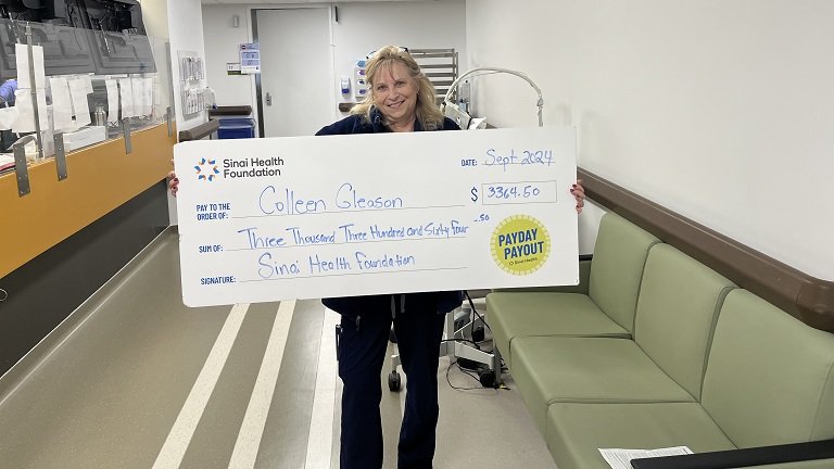 Photo of Colleen Gleason holding the winning Payday Payout cheque