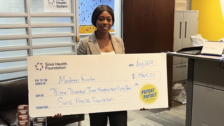 Photo of Madeen Foote holding the winning Payday Payout cheque