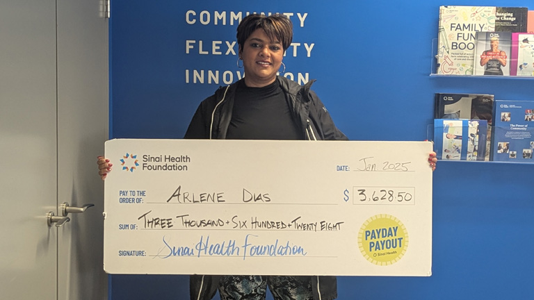 Photo of Arlene Dias holding the winning Payday Payout cheque