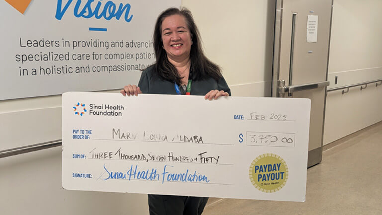 Photo of Maria Lorna Aldaba holding the winning Payday Payout cheque