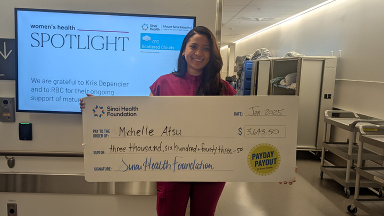 Photo of Michelle Atsu holding the winning Payday Payout cheque