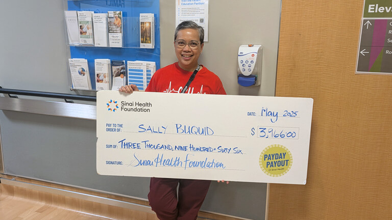 Photo of Sally Buquid with Payday Payout cheque