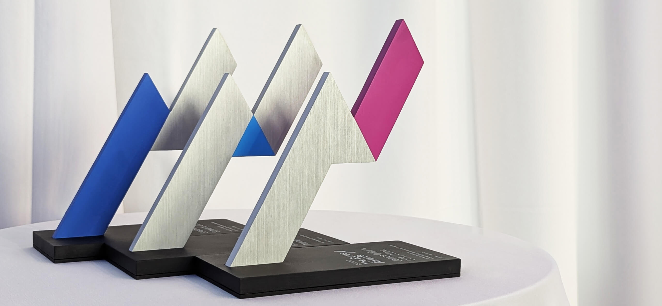 Three Ezra awards displayed on a table against a clean white background
