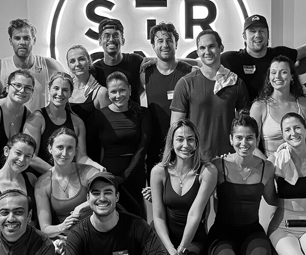 A large group of smiling people posing together in a gym set